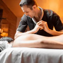 Man receiving deep tissue massage on massage table at home by Hitadeha Wellness Therapist. Call 9211053153 to book your therapy session.