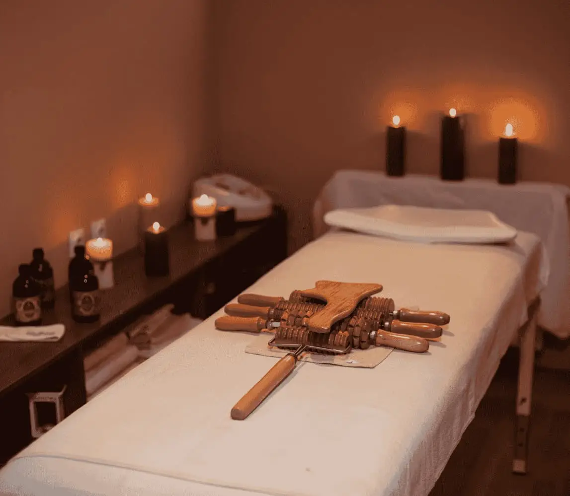 Beautifully arranged massage room setup with massage table, candles & soothing ambiance by Hitadeha Wellness. Call 9211053153 to book therapy at home.