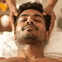 Man lying on massage table receiving Abhyanga Ayurvedic oil massage therapy at home by Hitadeha Wellness Therapist. Call 9211053153 for booking.